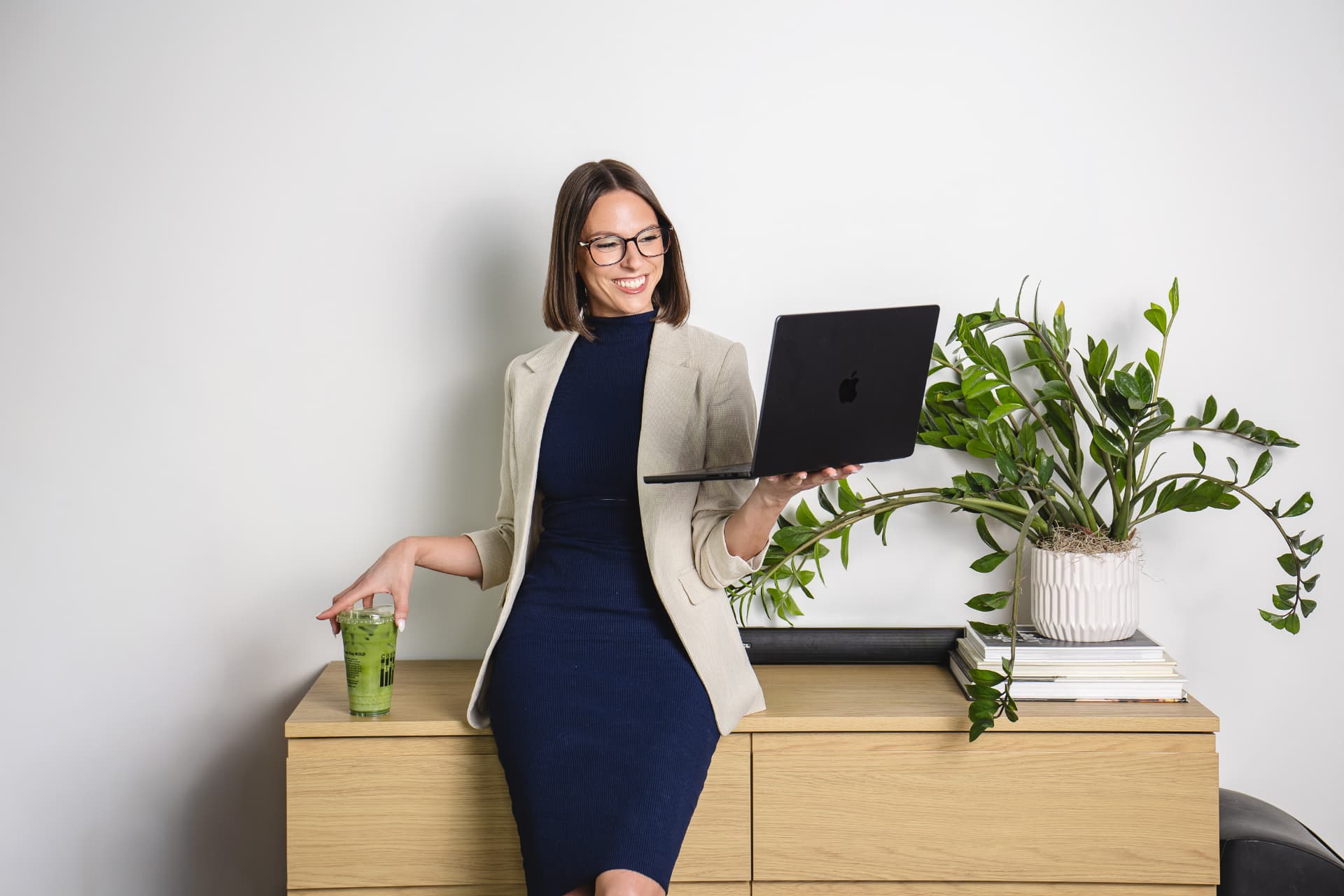 Krista smiling at her laptop with a matcha beside her