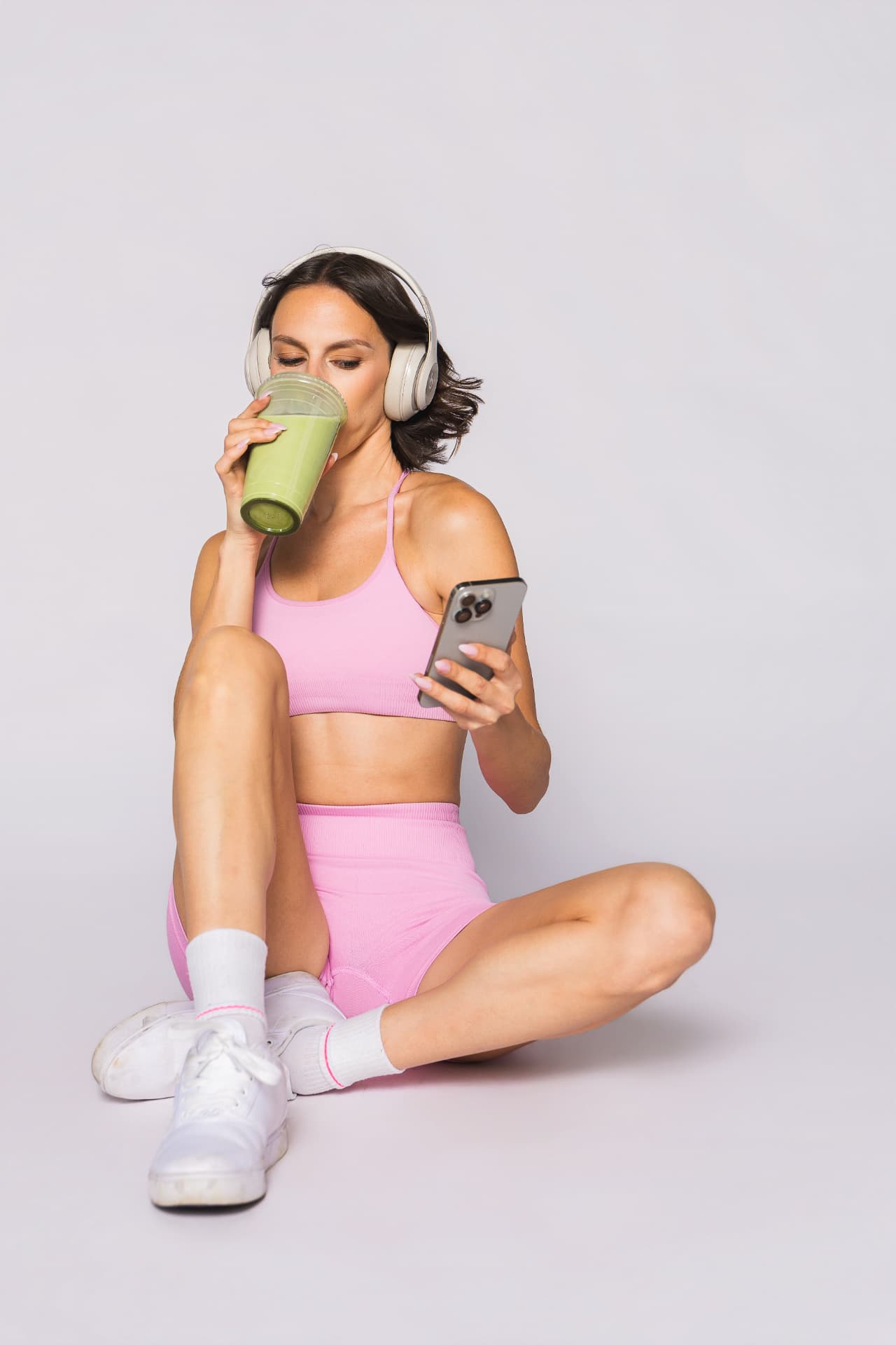 Krista in pink workout clothes enjoying a matcha after moving her body